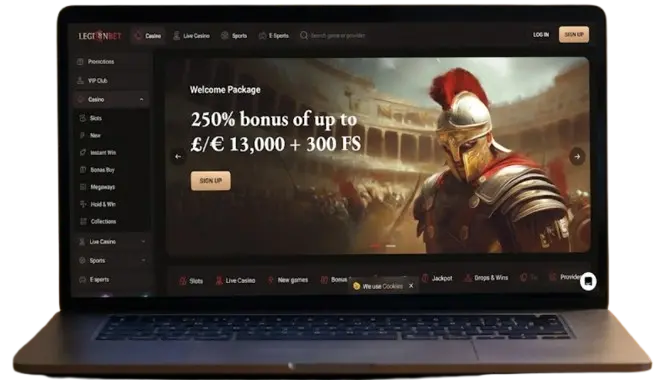 A modern laptop on a wooden table displaying the LegionBet online casino website, showcasing the homepage and welcome bonus offer.